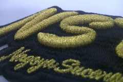 黒の生地をベースにレーシングチームのロゴをオリジナル3D刺繍ワッペンとして製作した事例のアップ。