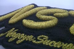 黒の生地をベースにレーシングチームのロゴをオリジナル3D刺繍ワッペンとして製作した事例のアップ。
