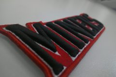 黒糸とその外側を白い糸が縁取ることで、文字がくっきりと浮き上がった3D刺繡の制作事例のアップ。