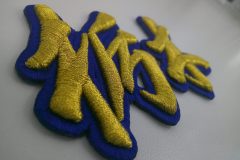 金糸の3D文字刺繍ワッペンの左サイドからのアップ。