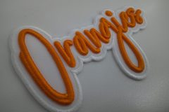 白い生地にオレンジ色の糸で加工された3D文字刺繍ワッペン。