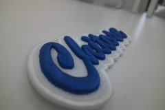 白のエンブクロス生地を土台にロイヤルブルー糸でチーム名を3D刺繍ワッペンとして製作した加工事例。横からのアングル。