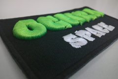 黒の生地をベースに蛍光グリーンと白の糸で3D刺繍を加工した、刺繍屋HONESTの制作事例。横からの撮影。