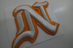 オレンジと銀糸の二色で野球チームのロゴ文字を3D刺繍ワッペンの加工事例。千葉の刺繍屋HONESTが製作。