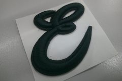 「E」文字の筆記体ロゴデザインを黒糸で加工した、オリジナル3D刺繍ワッペンの制作事例。