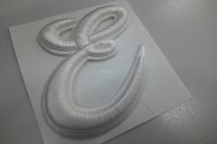 「E」文字の筆記体ロゴデザインを白糸で加工した、オリジナル3D刺繍ワッペンの制作事例。