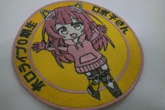 黄色の生地に女の子の全身を刺繍した円形のオリジナル刺繡ワッペンの制作実績。