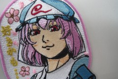 金糸の文字をワンポイントとしたキャラクターのオリジナル刺繡ワッペンの制作実績。