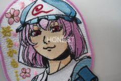 金糸の文字をワンポイントとしたキャラクターのオリジナル刺繡ワッペンの制作実績。