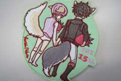 女の子と男の子が苺を抱えながら手をつないでいる後ろ姿を刺繡した、オリジナル刺繡ワッペンの制作実績。