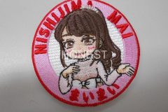 ピンクの衣装を着た女の子を中心にあしらい、周りをピンクと赤の糸で刺繡した、オリジナル刺繡ワッペンの制作実績。