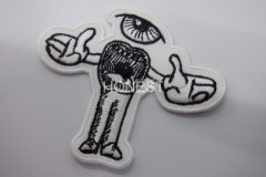 白色の生地に黒糸で細かく目と口を刺繡したキャラクターの刺繡ワッペン.
