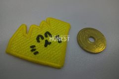 黄色い生地で形を模って、黒色で笑った顔を刺繡した、オリジナル刺繡ワッペンの制作実績。