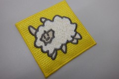 四角い黄色の生地の中心にもこもこの羊を刺繡した、オリジナル刺繡ワッペンの制作実績。