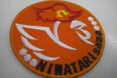 オレンジ色の生地にサテン縫いの線模様でニワトリを表現したオリジナル刺繡ワッペンの制作実績。