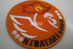 オレンジ色の生地にサテン縫いの線模様でニワトリを表現したオリジナル刺繡ワッペンの制作実績。
