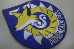 青色のツイル生地に黄・白・黒糸で九尾の狐を刺繡した、オリジナル刺繡ワッペンの制作実績。。