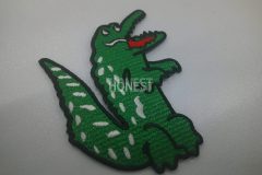 緑色のクロス生地を活かしたワニの刺繡ワッペンの制作事例。
