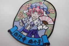 桜の昇華転写プリントを施した生地に扇を持ったキャラクターの刺繍を組み合わせた、オリジナル刺繡ワッペンの制作実績。