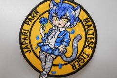 オレンジ色の生地にマルタタイガーの女の子と青いバラを刺繡した、オリジナル刺繡ワッペンの制作実績。