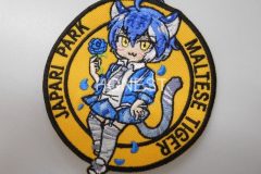 オレンジ色の生地にマルタタイガーの女の子と青いバラを刺繡した、オリジナル刺繡ワッペンの制作実績。