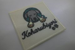 クリーム色の生地に毛糸玉と寝ている犬のイラストと肉球が可愛いオリジナル刺繡ワッペンの制作実績。