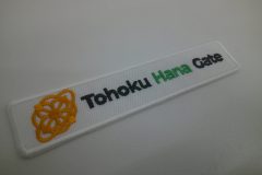 白い生地に黄・黒・緑の三色で細かいマークも綺麗に仕上げた企業のオリジナル刺繡ワッペンの制作実績。