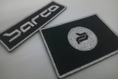 黒色の生地に銀糸でロゴを刺繡した、オリジナル刺繡ワッペン二種類の制作実績。