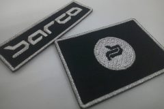 黒色の生地に銀糸でロゴを刺繡した、オリジナル刺繡ワッペン二種類の制作実績。