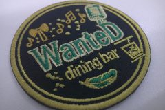 店名の周りに羽やマイク、音符やグラスといったゆかりのあるイラストを刺繡した、オリジナル刺繡ワッペンの制作実績。