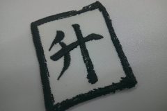 黒の刺繍糸で文字や縁のカスレ具合も細かく表現した刺繡ワッペンの制作事例。