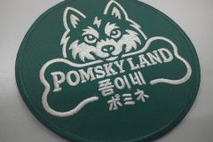 緑色の生地に白色の糸でポンスキーと骨と店名のロゴを刺繡した、オリジナル刺繡ワッペンの制作実績。