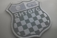 レースで使用されるチェッカーフラッグをモチーフにチーム名刺繡した、オリジナル刺繡ワッペン（グレー生地）の制作実績。