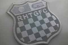 レースで使用されるチェッカーフラッグをモチーフにチーム名刺繡した、オリジナル刺繡ワッペン（グレー生地）の制作実績。