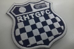 レースで使用されるチェッカーフラッグをモチーフにチーム名刺繡した、オリジナル刺繡ワッペン（黒生地）の制作実績。