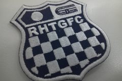 レースで使用されるチェッカーフラッグをモチーフにチーム名刺繡した、オリジナル刺繡ワッペン（黒生地）の制作実績。