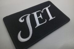 黒のクロス生地に白色の糸で大きく文字を刺繡したオリジナル刺繡ワッペンの制作実績。