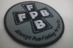 グレーのフェルト生地に黒と白糸でロゴマークを刺繡した、オリジナル刺繡ワッペンの制作実績。