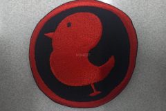 黒い生地に赤い糸で横向きの小鳥を大きく刺繡した、オリジナル刺繡ワッペンの制作実績。