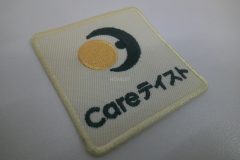クリーム色の生地に満月と三日月のイラストと会社名を刺繡した、オリジナル刺繡ワッペンの制作実績。