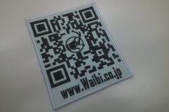 グレーの生地に黒糸で企業のQRコードとHPのURLを刺繡した、オリジナル刺繡ワッペンの制作実績。
