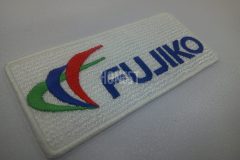 白色の生地に赤青緑の三本線のロゴと青色で企業名を刺繡した、オリジナル刺繡ワッペンの制作事例。