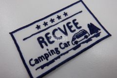白色の生地にネイビーの糸でワンボックスタイプの車と木々が会社名と共に刺繡されたオリジナル刺繡ワッペンの制作実績。