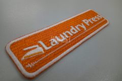 店名としわをアイロンで伸ばしたようなイラストを刺繡した、オリジナル刺繡ワッペンの色違いの制作事例。