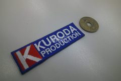 青色の生地で高さが五円玉大しかない大きさに赤白に企業ロゴと白糸で企業名を刺繍した、オリジナル刺繡ワッペンの制作事例。