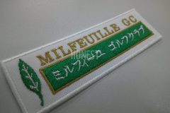 白のツイル生地を土台とし、緑・白・マットゴールドの三色でゴルフクラブのロゴを刺繍した、オリジナル刺繍ワッペンの作品事例。