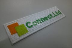 白の生地をベースに、人材派遣会社の社名ロゴを刺繍加工した制作実績。刺繍屋HONESTが制作。