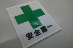 よく見かける安全マークを刺繍ワッペンとして製作した加工事例。白糸・緑糸・黒糸の三色。