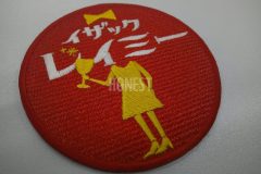 赤の生地に濃いイエローと白で刺繍をした飲食店のロゴ刺繍ワッペン。女性がグラスを持ったシルエットがお洒落な作品。
