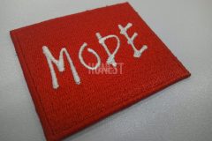 赤のボックスロゴに白糸で「MODE」とシンプルに刺繍した、総刺繍ワッペンの制作事例。